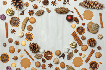 Christmas background of cones, cinnamon, nuts, spices, cookies on light boards. In the center there is free space for text in the form of a circle