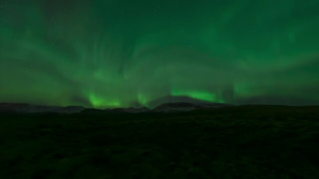 Aurora borealis over snow mountains and wide open tundra in Iceland
