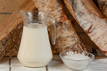 Milk with salt on the background of birch wood