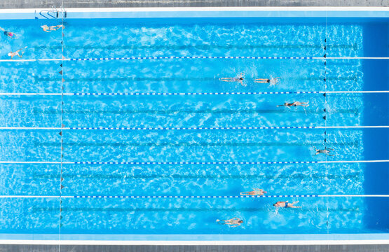 People training in outdoor swimming pool, top view