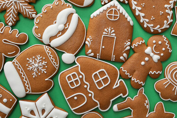 Different Christmas gingerbread cookies on green background, flat lay