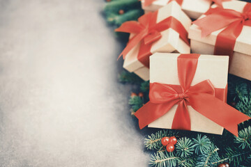 Toned image of gifts and present boxes on fir branches, pines, red berries background; festive Christmas and New Year celebration card