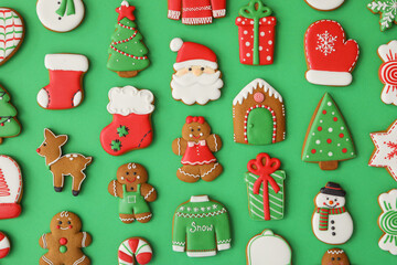 Different Christmas gingerbread cookies on green background, flat lay
