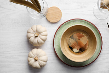 Autumn table setting with pumpkins on white wooden background, flat lay