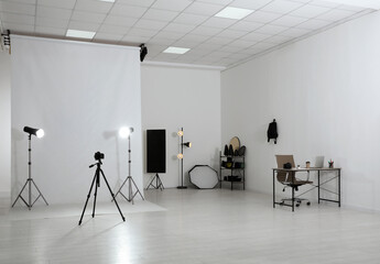 Photo studio interior with set of professional equipment and workplace