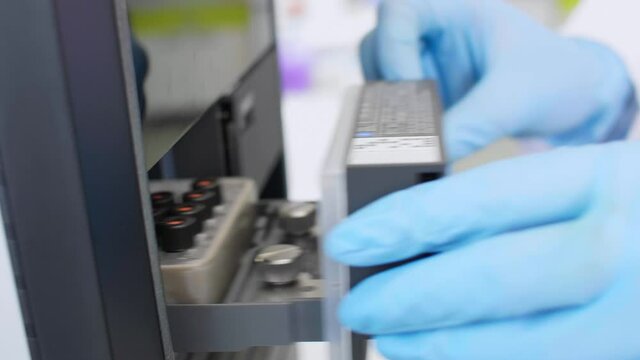 Scientist taking cbd samples from chromatography machine in laboratory