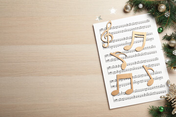 Flat lay composition with Christmas music sheets on wooden background. Space for text