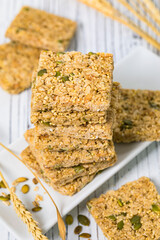 Multigrain Cereal Crunchy Squares Bars with Pumpkin Seeds on Wooden Background. Selective focus.