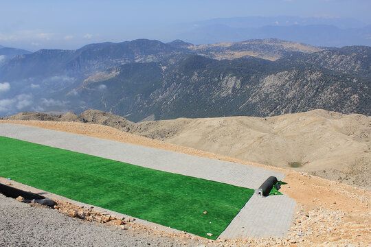 Summit of Tahtali Dag (Olympos Mountain), 2365 m MSL with paraglider's (paragliding) take off point visible on foreground and turkish Taurus Mountains range in the background, Kemer, Antalya Region