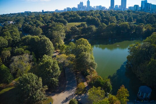 Panoramic aerial shot of the famous Piedmont park and Lake Clara meer with Atlanta skyline in background shot during golden hour by a drone