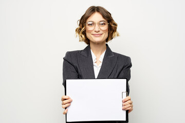 Naklejka premium Business woman with a folder of documents on a light background cropped view and shirt suit