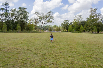 Fototapeta premium Child Walking in a Field of Grass