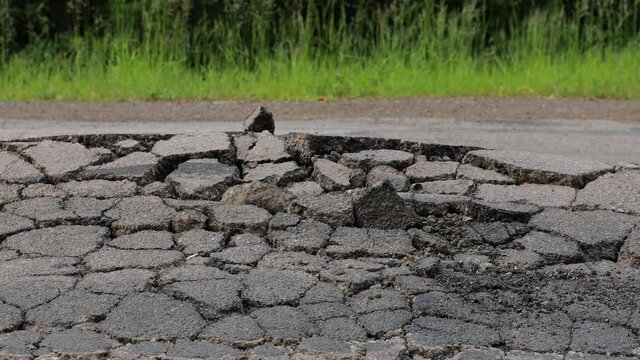 destroyed broken asphalt road natural disaster - climate change - cracks and swelling - geology - close up