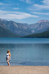 Fototapeta na wymiar Attractive young woman poses at the scenery of Bowman Lake in Glacier National Park Montana