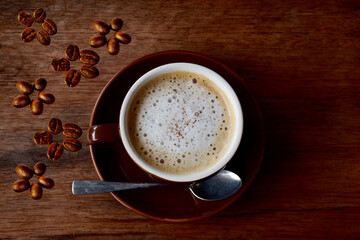 Cup of coffee and coffee beans put on the wooden