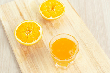 Fresh orange juice on wooden cutting board
