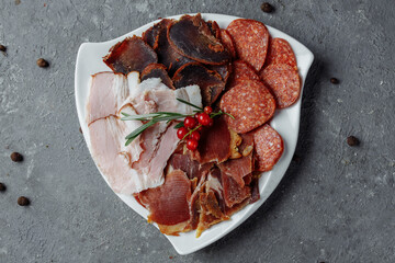 Mix of sliced meat on a white plate