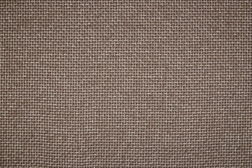 background of rough cloth. textile material in a brown colour. burlap close-up. texture of furniture fabric.