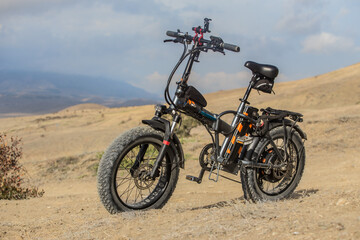 Electric Bicycle On A Hill On A Background Of Mountains.