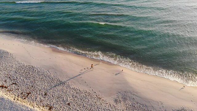 Woman makes a heart in the sand on beautiful white sand beach and waves