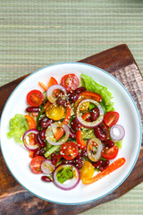 Plate with Pan-Asian sesame salad on wooden stands.