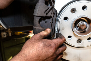 New brake disc with an anti-corrosion layer, mounted on the front hub, installing the brake pads, putting on the spring.