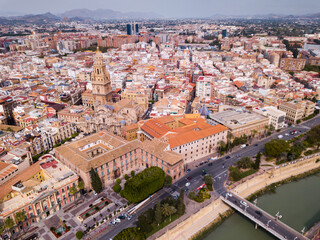 Fototapeta na wymiar View from drone of residential areas and catholic cathedral belfry of Spanish town of Murcia on Segura river