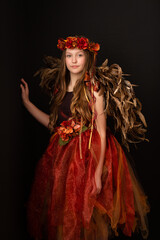 Young teen girl dressed in holiday gown and feather wings