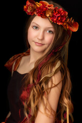 Naklejka premium Closeup of young girl with green eyes, flower crown and red dress
