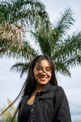 woman smiling with a palm tree behind