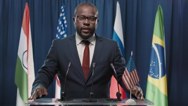 Medium portrait shot of African American politician representing USA participating in international forum speaking about global issues