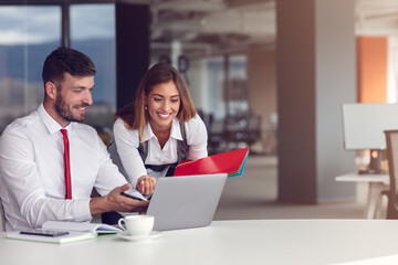 Couple of busy colleagues working together in modern office