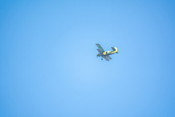 Retro green biplane plane in the blue sky