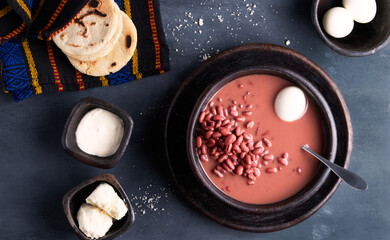 Traditional salvadoran red beans soup served with boiled eggs, cream, cheese and corn tortillas,latin america food