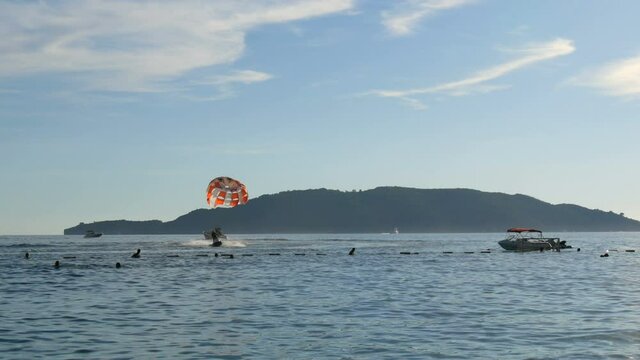 People are resting flying on parasailing over the Adriatic Sea in the Bay of Kotor, Montenegro, outdoor activities.