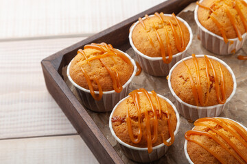 Many sweet tasty muffins on wooden board, copy space