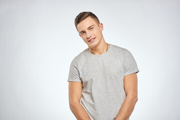 Fototapeta premium man in gray t-shirt emotions light background cropped view