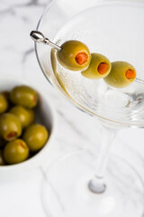 vodka or gin martini cocktail with fresh green olive garnish