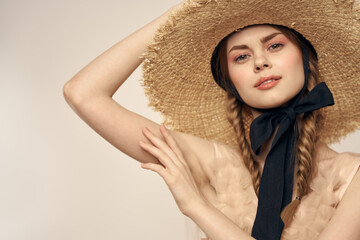 Nice girl in a straw hat with a black ribbon and in a dress on a light background romance model fun emotion