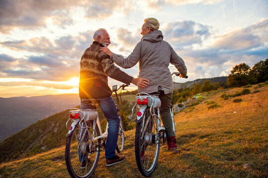 Active Senior Couple Riding Bikes In Park