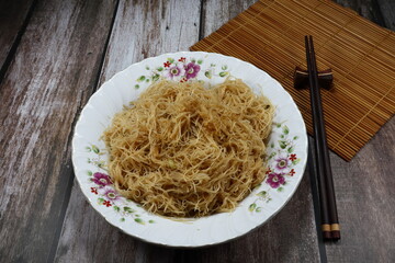 Fried and stirred instant rice noodle seasoning with pepper and soy sauce on the plate. Famous traditional vegetarian ingredient menu in Asia restaurant. 