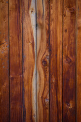 Obraz premium Wooden background, close-up. Brown vertical boards. Facing the exterior walls of the house. Ramshackle wall with peeling paint.