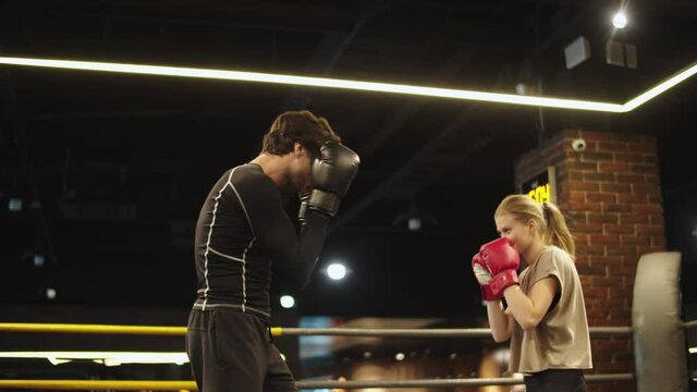 Sporty athletes enjoying training in sport club. Sport couple boxing at gym