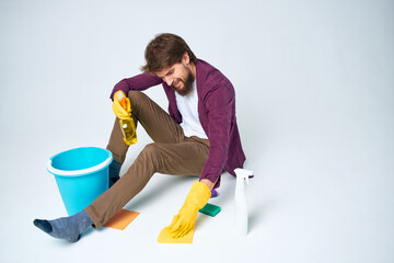 Cleaner sits on the floor with a bucket of homework service room interior