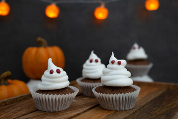 Halloween ghost cupcakes , homemade sweet chocolate muffins with meringue ghost