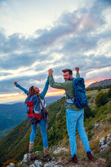 Couple on Top of a Mountain Shaking Raised Hands