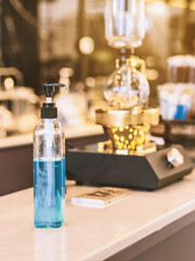 Blue alcohol gel bottle for hands cleaning to prevent the spreading of the Corona virus (Covid-19), Place the entrance service for customers  in the cafe. Healthcare concept. New normal lifestyle.
