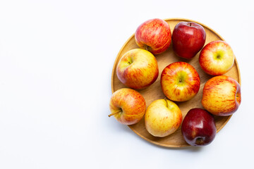 Fresh juicy apples on wooden plate on white