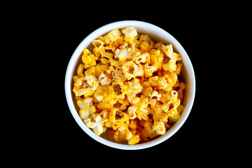Popcorn in bowl on black background.