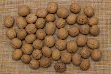 Heap of scattered walnuts in shell. Walnut market. Background from walnuts. Healthy walnuts. Natural walnut background texture pattern Abstract walnuts